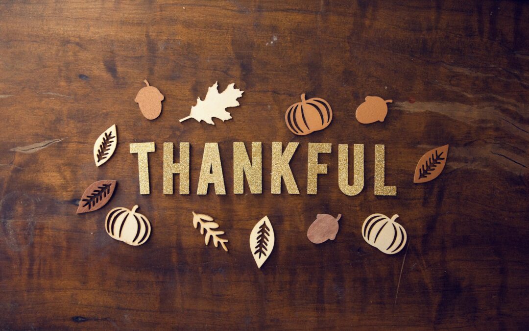 Glitter letters spelling out "Thankful" on a wooden table